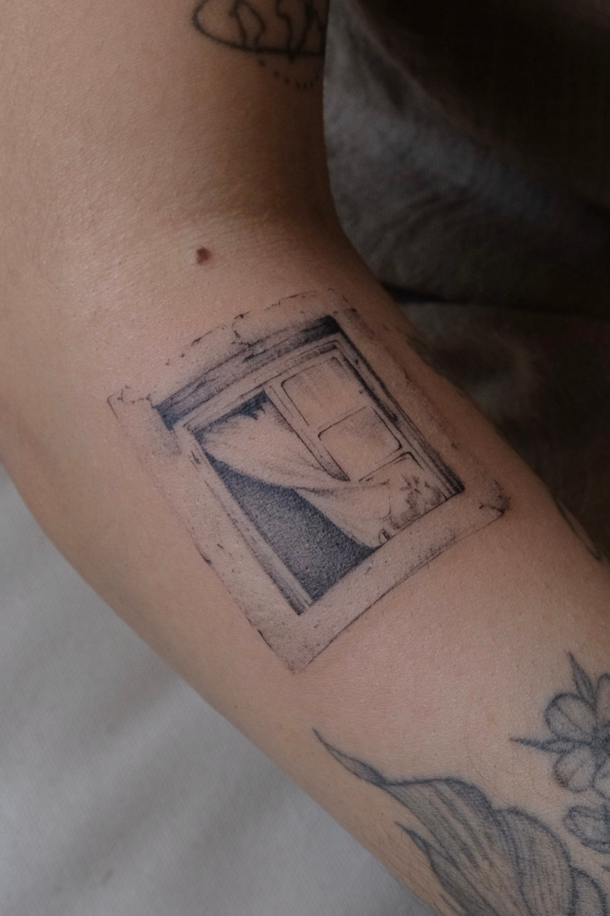 Micro-realist window tattoo on the inner arm